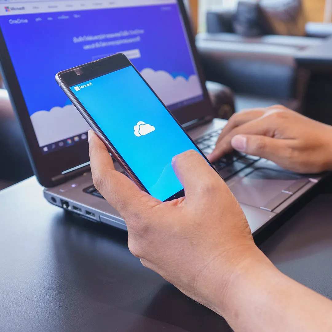 person opening onedrive app on mobile and laptop